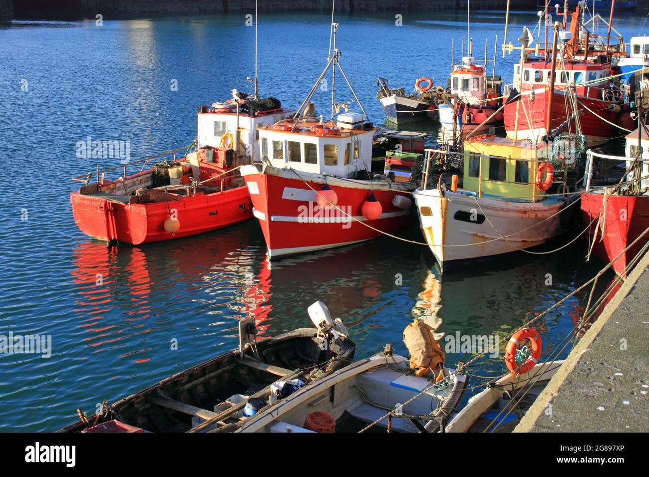 Small colourful fishing boats and reflections in Howth, County Dublin. Stock Photo
