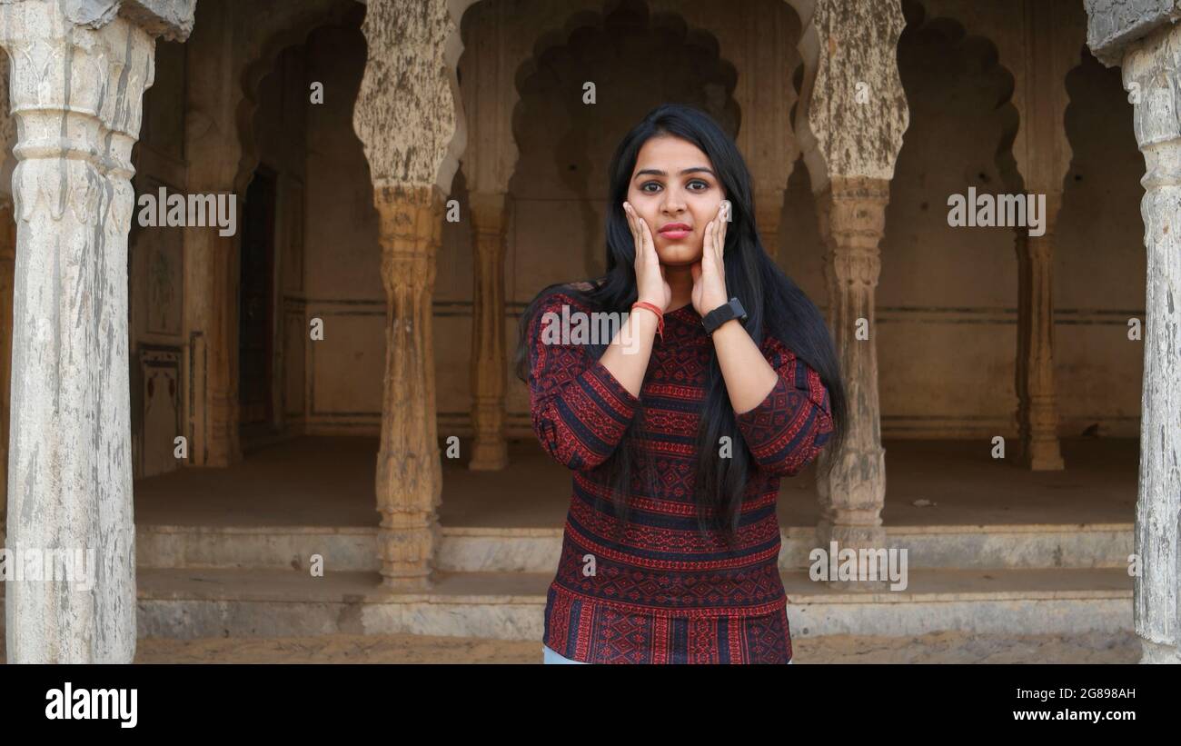 A young Indian female holding her cheeks Stock Photo - Alamy