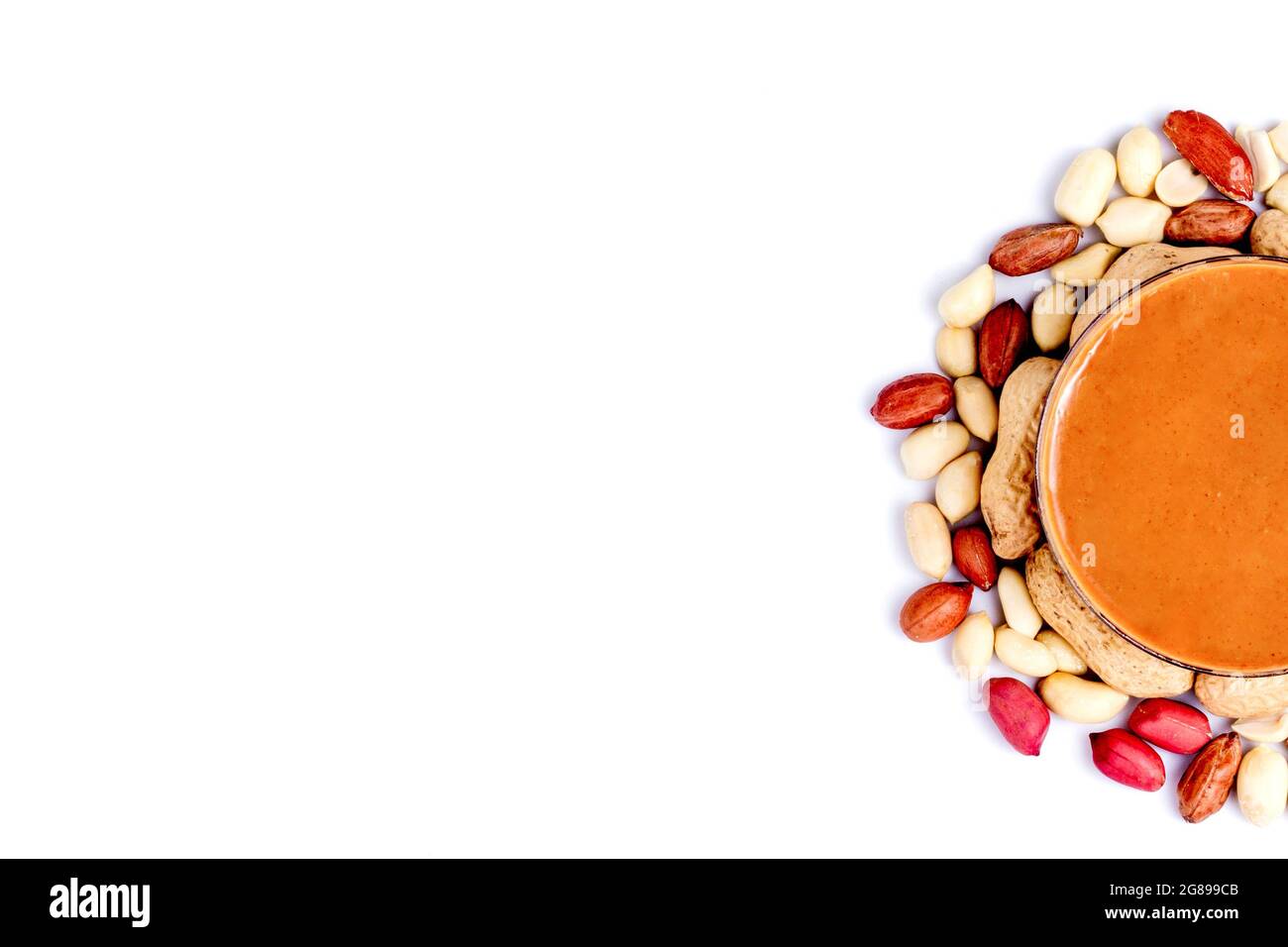 Peanut butter isolated and peanuts in the peel scattered on the white