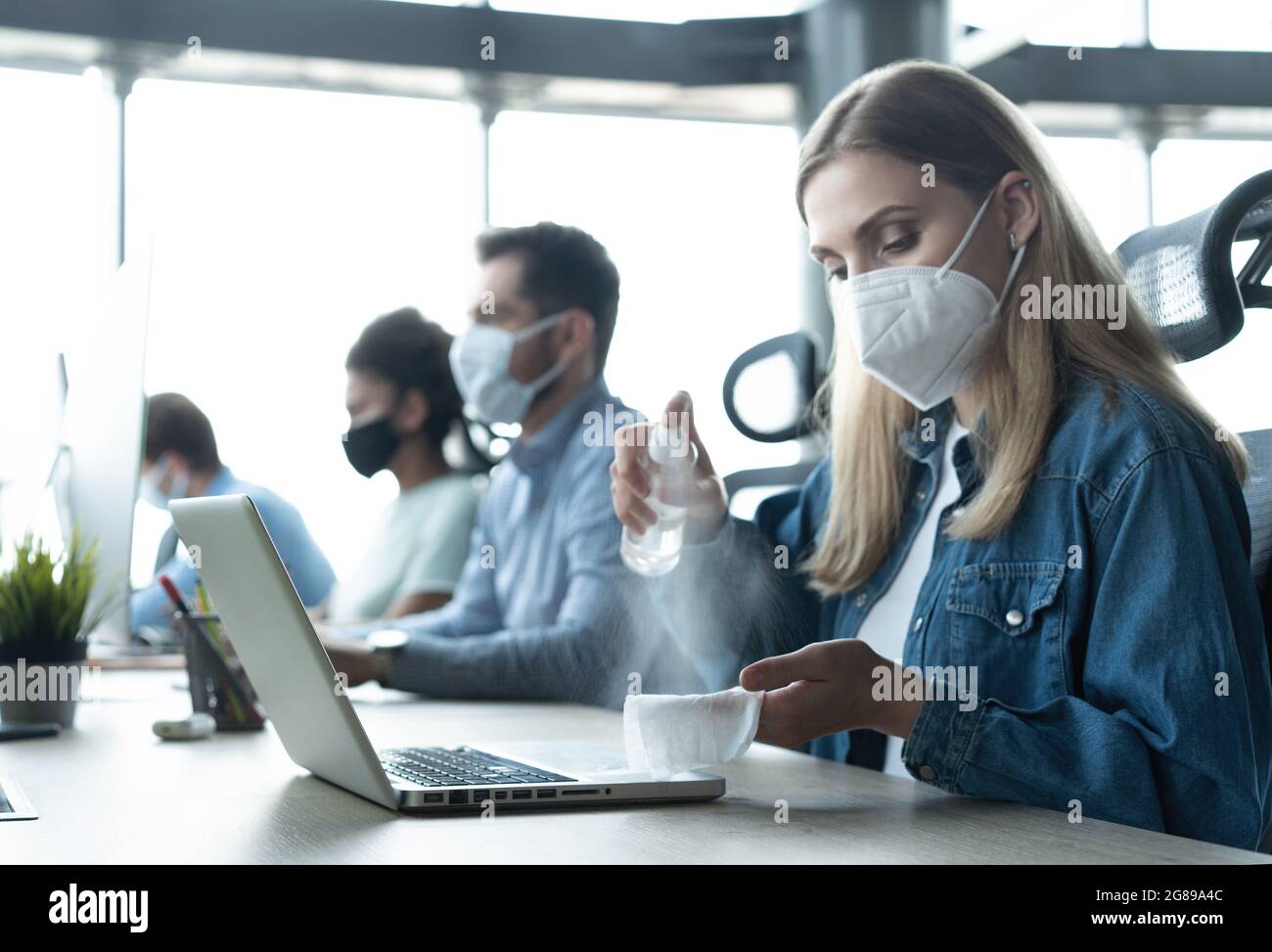 Portrait of young businesspeople with face masks working indoors in
