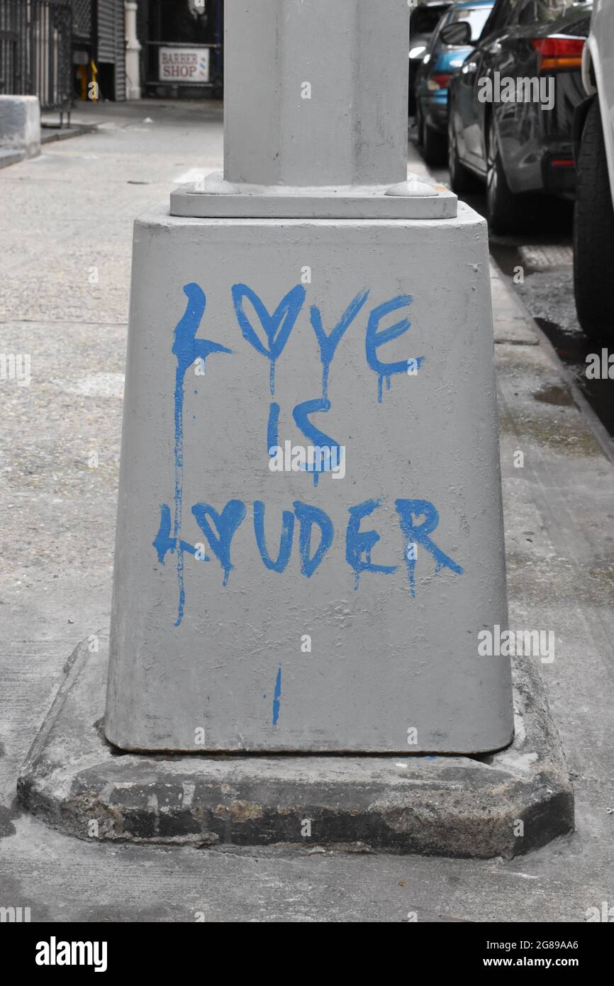 Graffiti on a lamppost base reading Love Is Louder, July 18, 2021, in New York Stock Photo