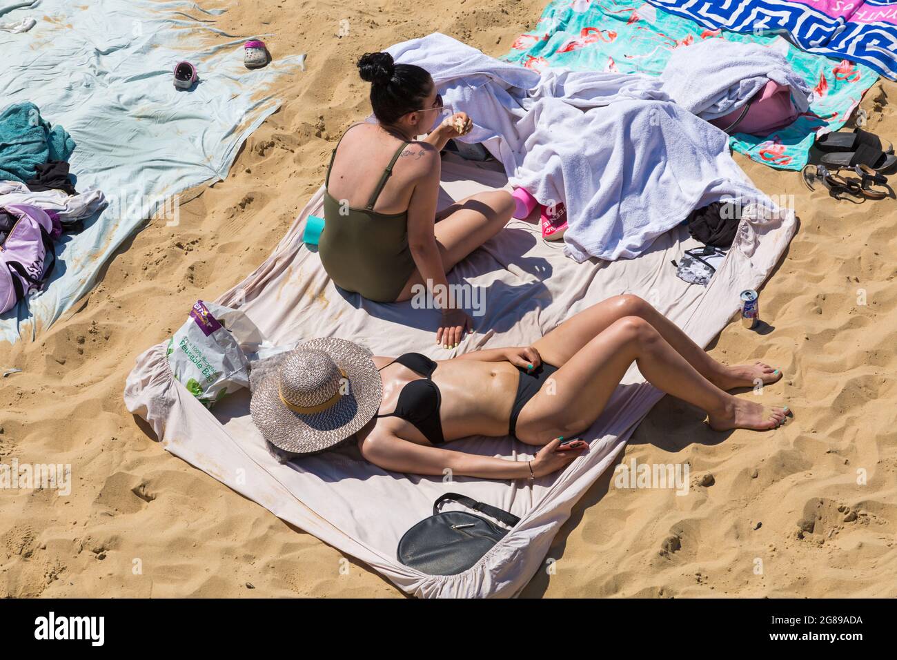 Bournemouth, Dorset UK. 18th July 2021. UK weather: hot sunny day at Bournemouth beach on the South Coast, as crowds flock to the seaside and sunseekers enjoy the sunshine in the heatwave. Beaches are packed with barely a spare space and car parks full.  Credit: Carolyn Jenkins/Alamy Live News Stock Photo