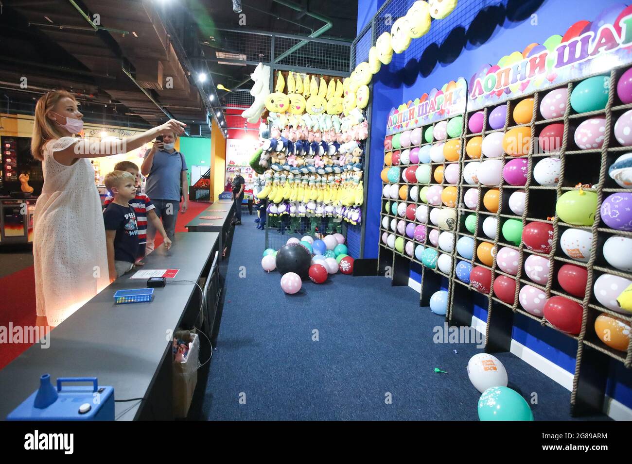 Moscow, Russia. 18th July, 2021. A woman plays the Pop the Balloon game at  the Dream Game Center, at the Dream Island amusement park. The two-storey  center has over 300 arcade machines,