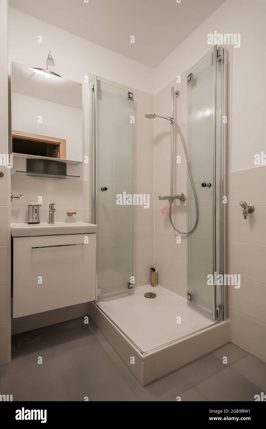 Glance into a very small bathroom with a special solution for the shower enclosure to create more space Stock Photo