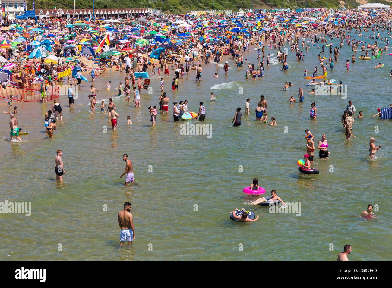 Bournemouth, Dorset UK. 18th July 2021. UK weather: hot sunny day at Bournemouth beach on the South Coast, as crowds flock to the seaside and sunseekers enjoy the sunshine in the heatwave. Beaches are packed with barely a spare space and car parks full.  Credit: Carolyn Jenkins/Alamy Live News Stock Photo