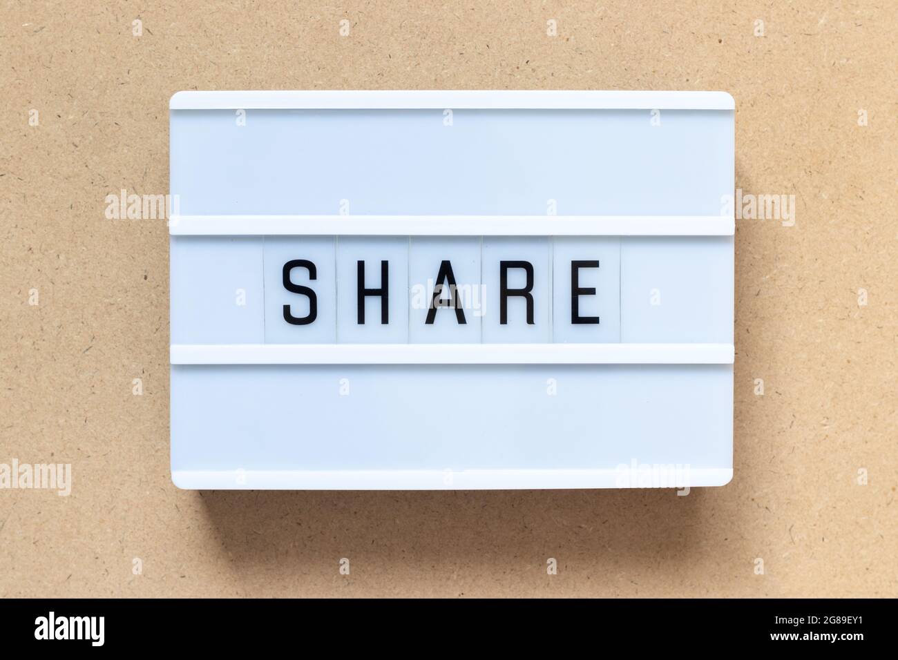 White lightbox with word share on wood background Stock Photo