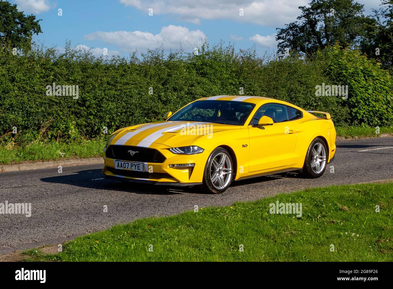 2008 yellow Ford Mustang 5038cc muscle car vehicle en-route to Capesthorne Hall classic July car show, Cheshire, UK Stock Photo