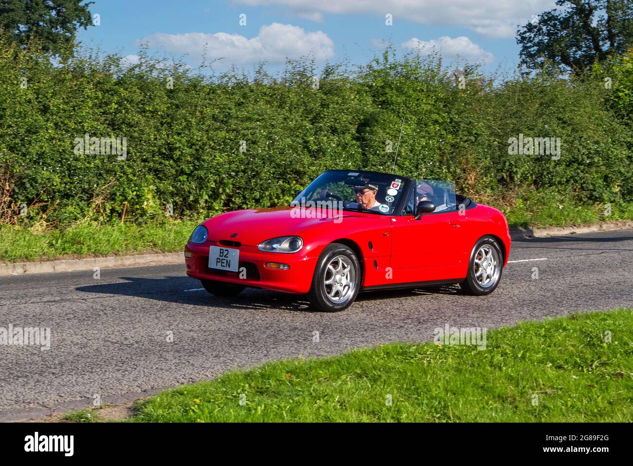 1995 90s red Suzuki Cappuccino 657cc sports kei cars, a vehicle en-route to Capesthorne Hall classic July car show, Cheshire, UK Stock Photo
