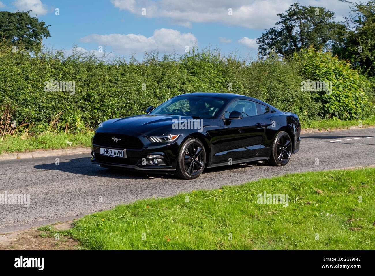 2017 black Ford Mustang 2261 cc petrol 2dr coupe vehicle en-route to Capesthorne Hall classic July car show, Cheshire, UK Stock Photo