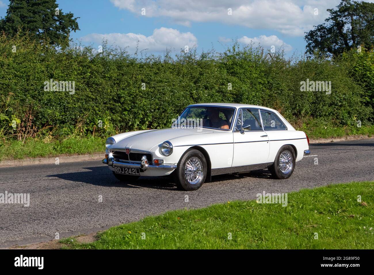 1972 70s  white  MG B GT 1798cc petrol vehicle en-route to Capesthorne Hall classic July car show, Cheshire, UK Stock Photo