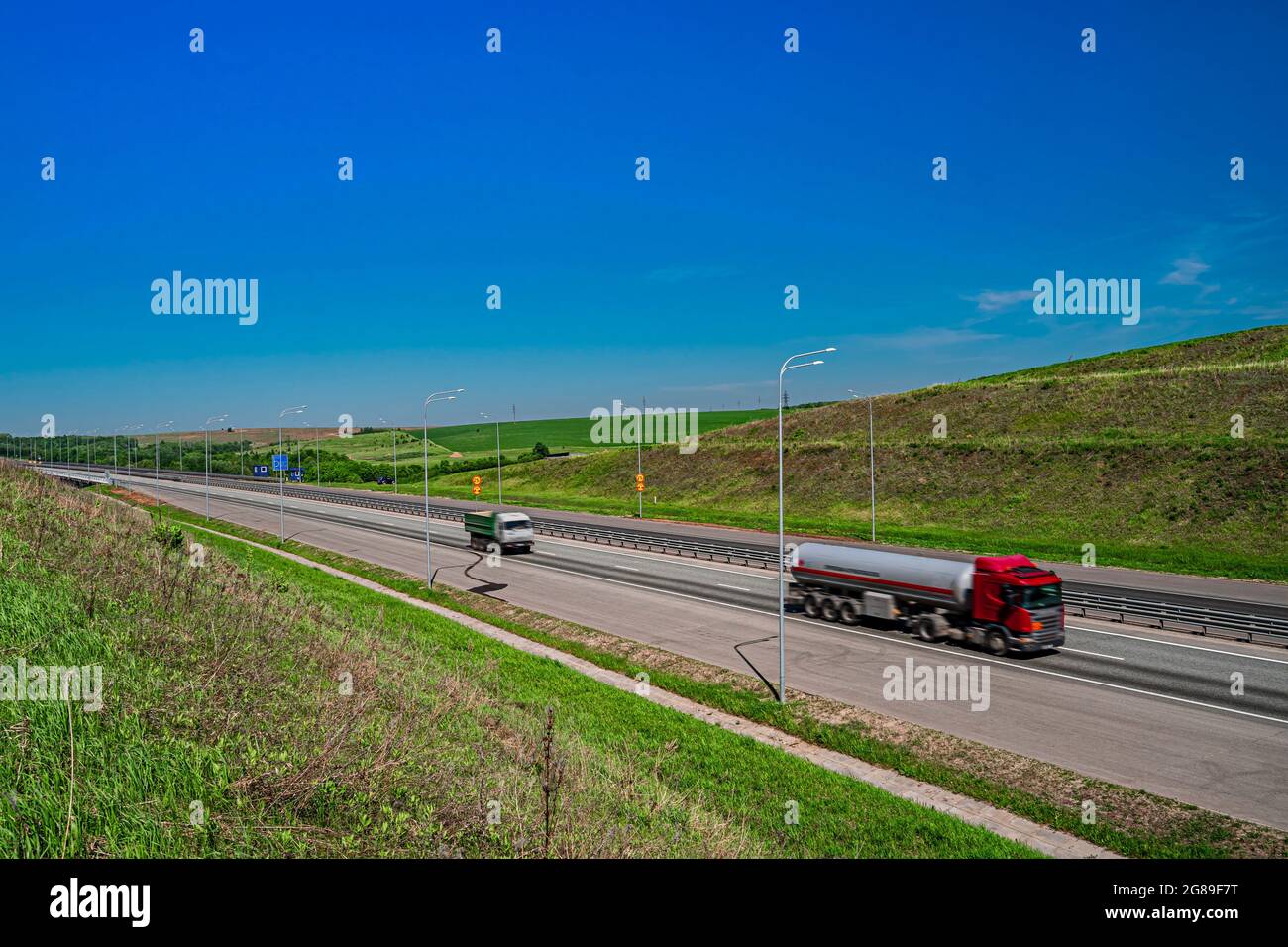 Asphalt road in a rural landscape. Trucks on the road. Russian roads.  Stock Photo