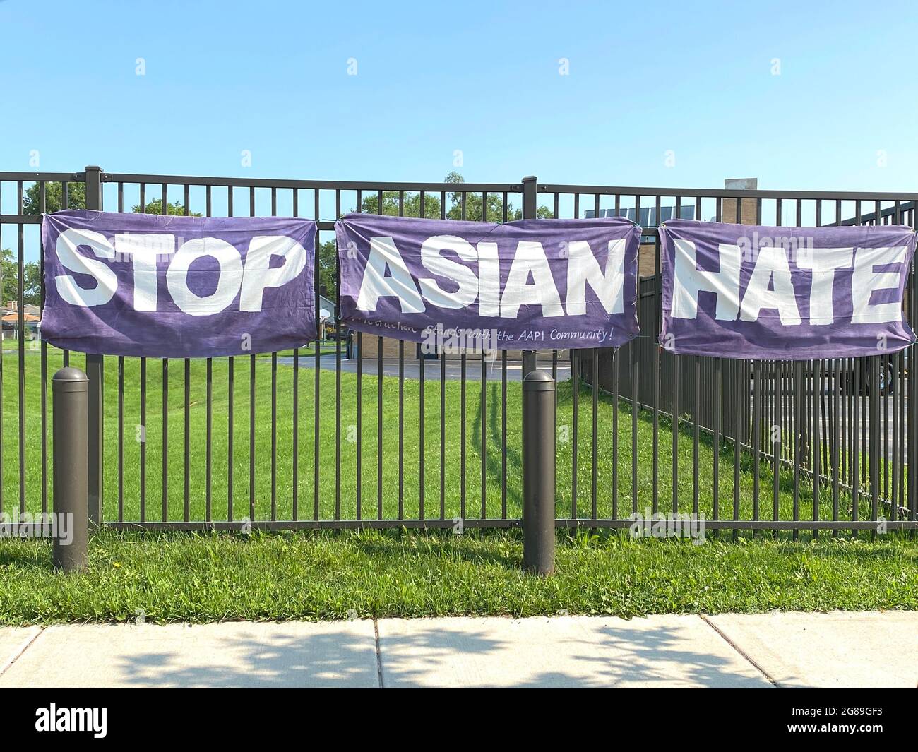 Stop Asian Hate banner hangs on a fence outside a middle school in suburban Chicago in support of the AAPI community. Stock Photo