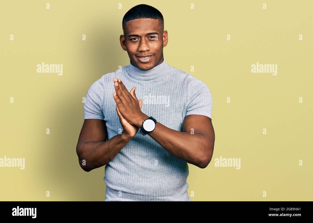 Young black man wearing casual t shirt clapping and applauding happy ...