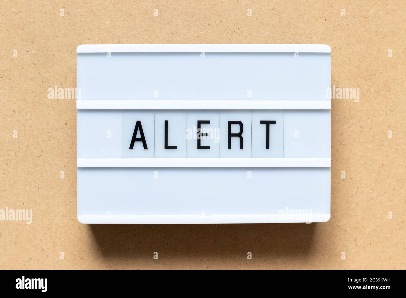 White lightbox with word alert on wood background Stock Photo