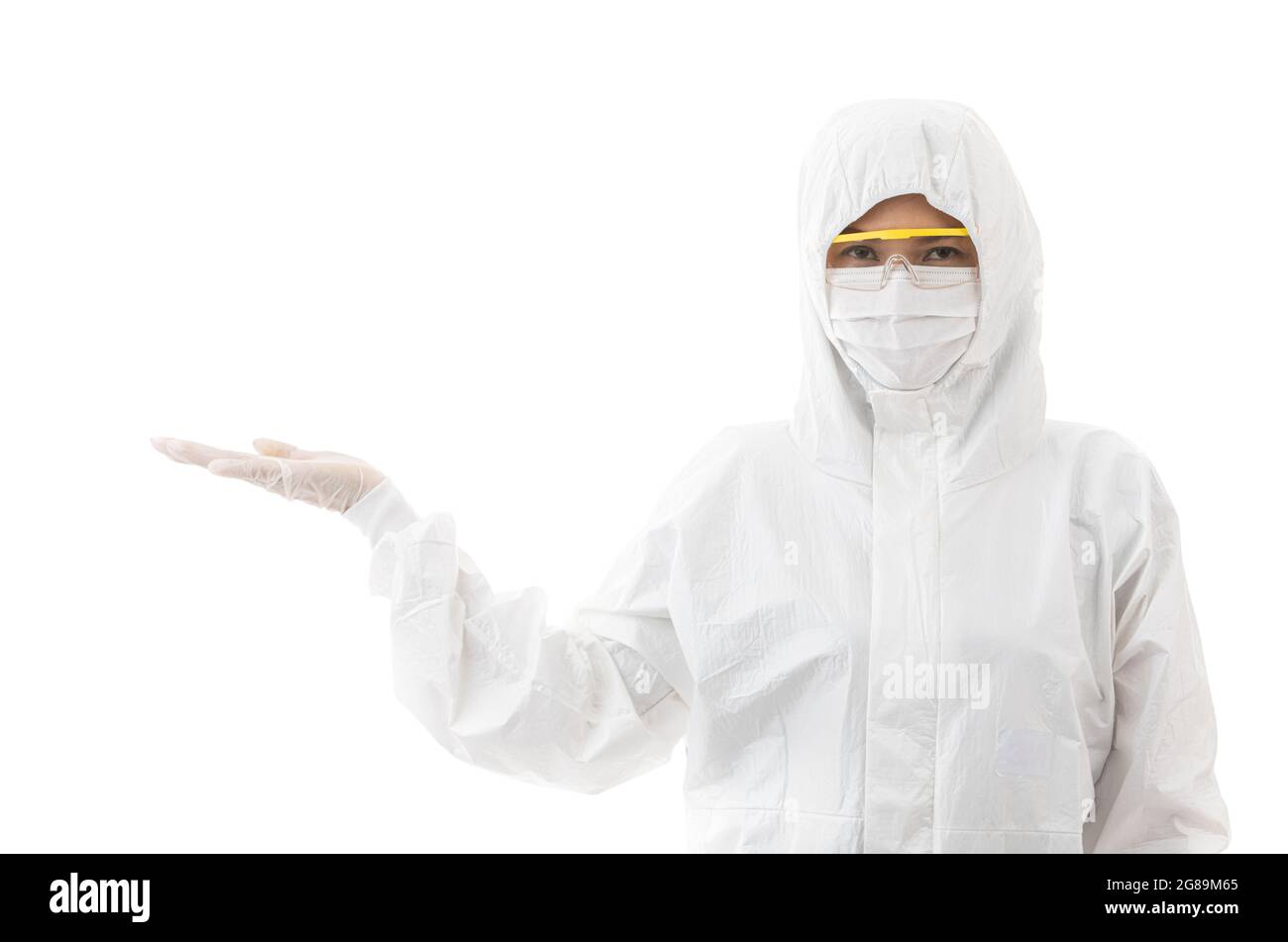 Woman in sterilize lab coat and safety eyeglasses standing and looking at camera, isolated on white background and pointing finger to copy space. Idea Stock Photo