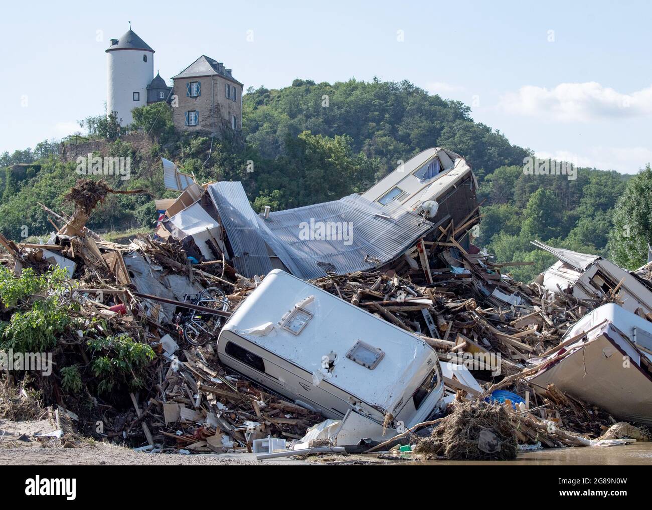 Altenahr, Germany. 18th July, 2021. Dozens of caravans, cars and mobile homes that were swept away by the flood wave hang squeezed together on an Ahr bridge in Altenahr. Numerous houses in the town were completely destroyed or severely damaged. Credit: Boris Roessler/dpa/Alamy Live News Stock Photo