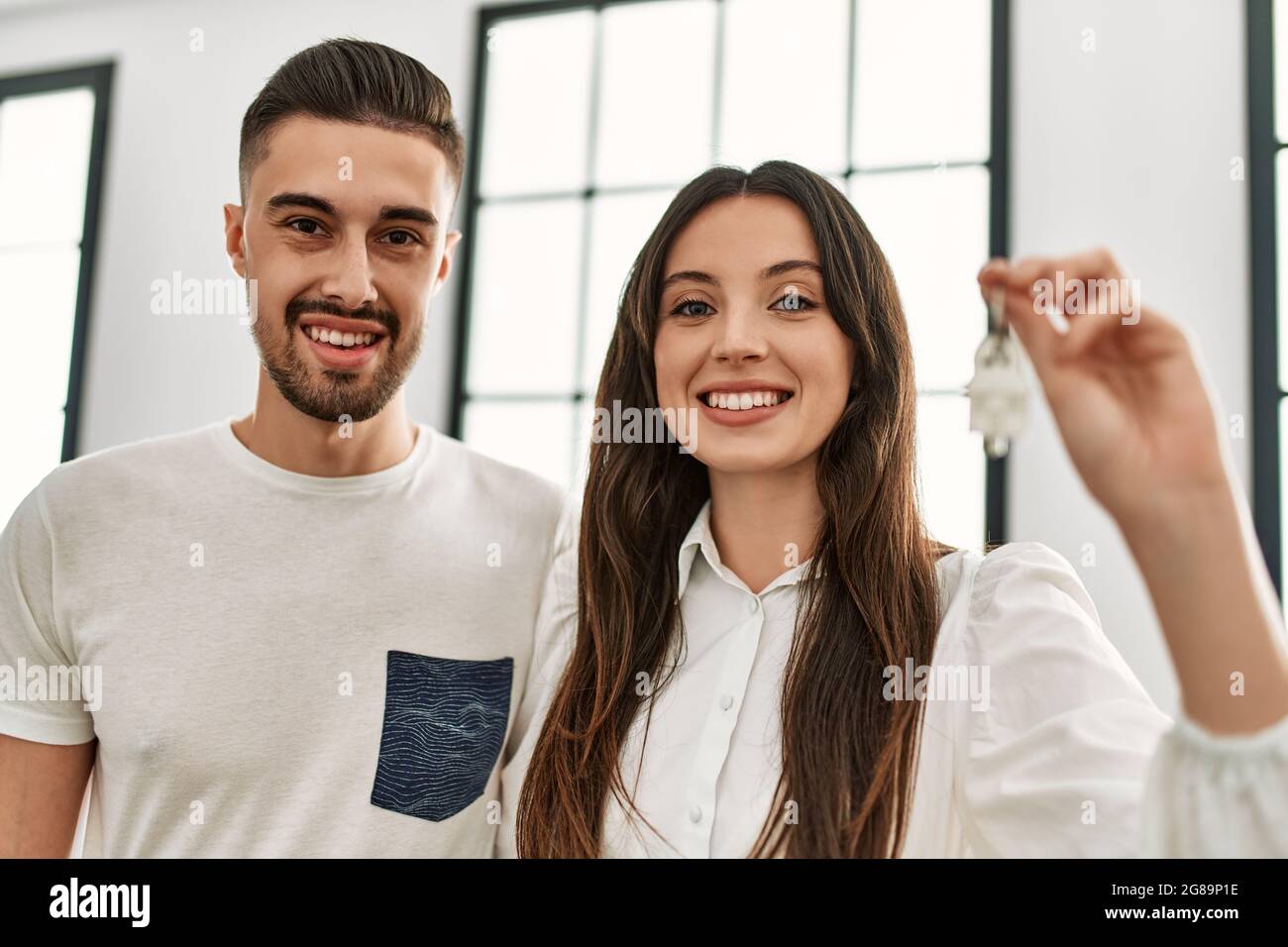Young hispanic couple smiling happy holding key of new home Stock Photo ...