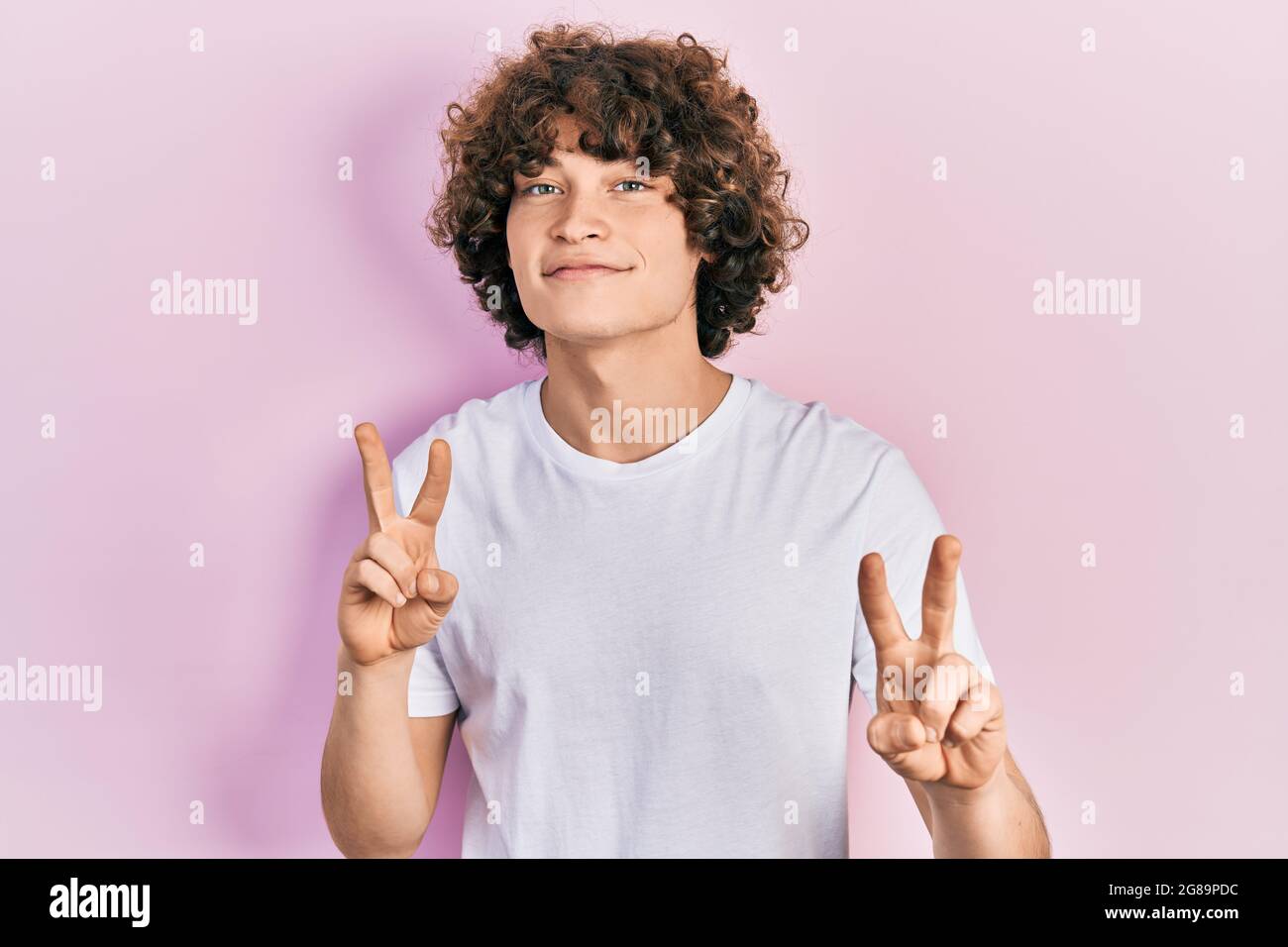 Handsome young man wearing casual white t shirt smiling looking to the ...