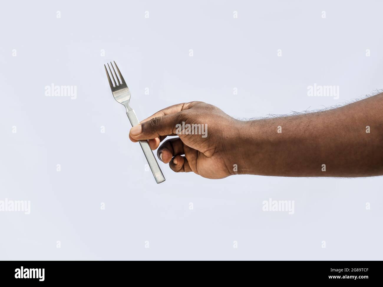 A male holding a fork with two fingers on isolated white background Stock Photo Alamy