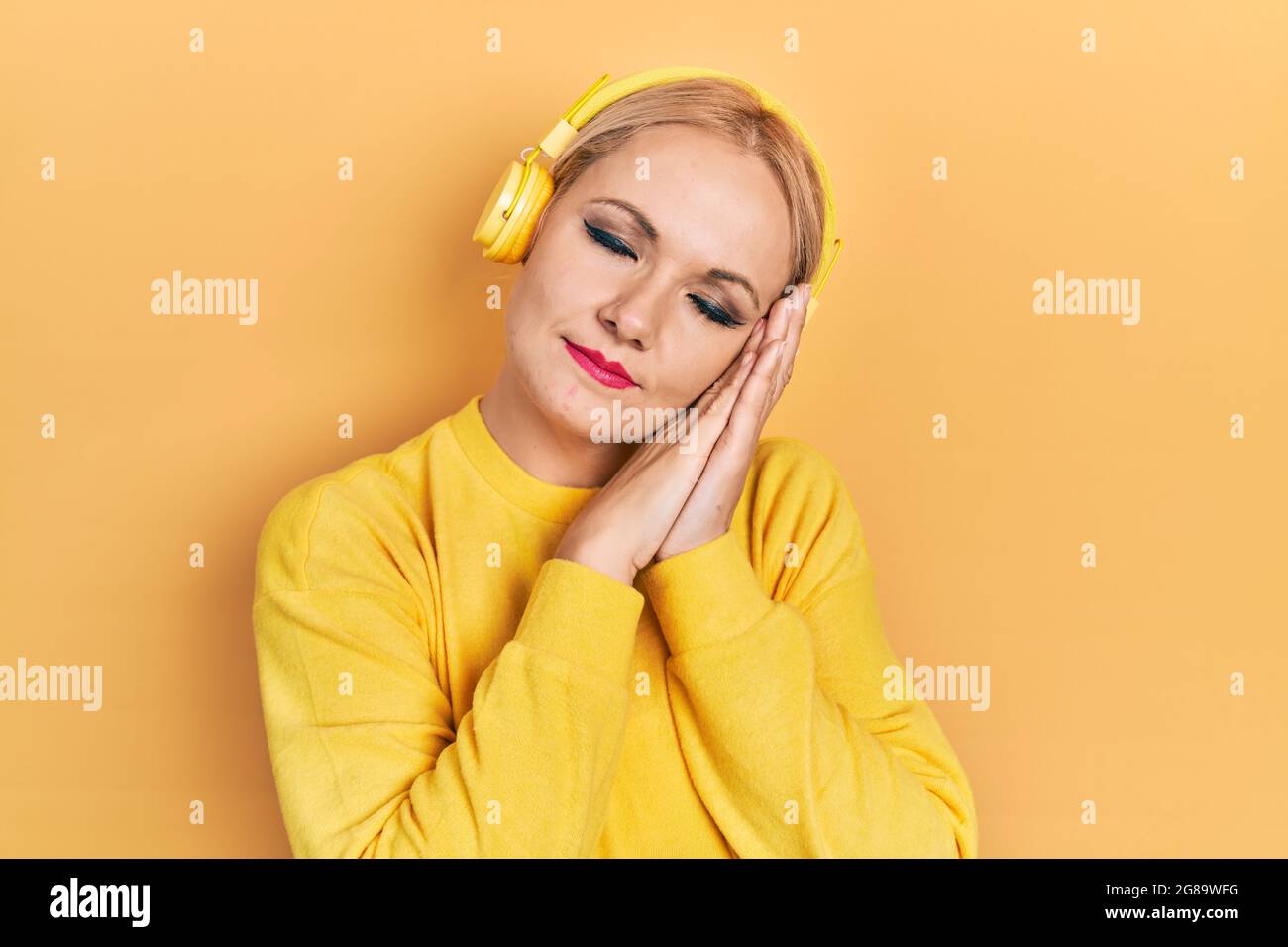 Young Blonde Woman Listening To Music Using Headphones Sleeping Tired Dreaming And Posing With 5744