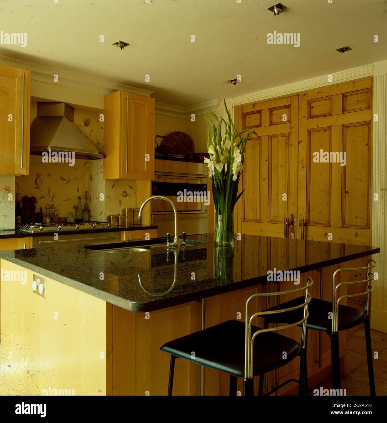 Stools at breakfast bar with granite worktop in modern kitchen Stock