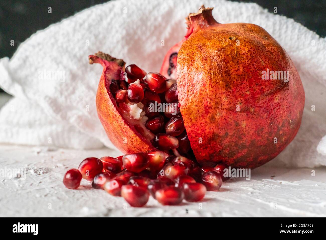 a large opened pomegranate fruit with many seeds grains fall pouring out of it Stock Photo Alamy