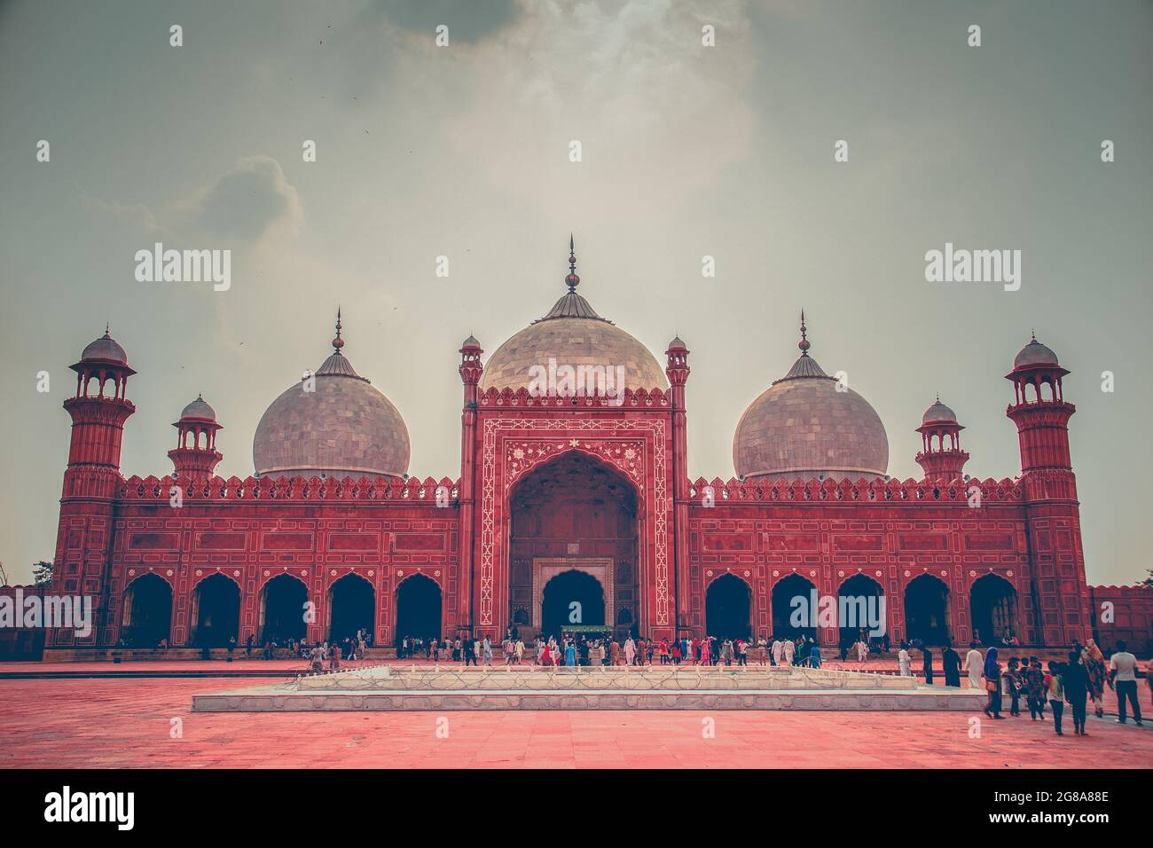 Badshahi masjid known as kings mosque in lahore at evening with kids playing in mosque’s garden and with the lahore city in background Stock Photo