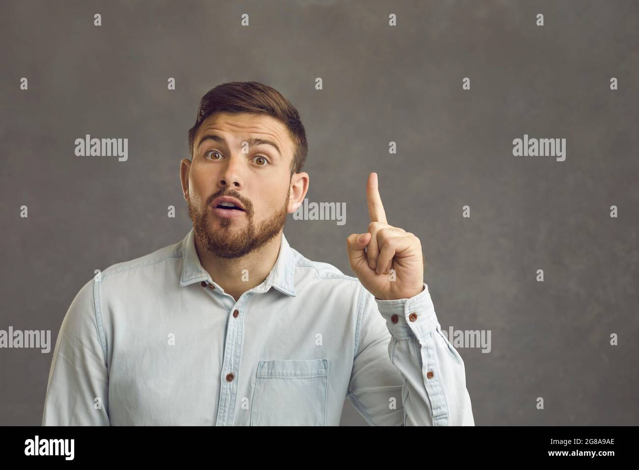 Man raises his index finger up as a sign that some bright idea or