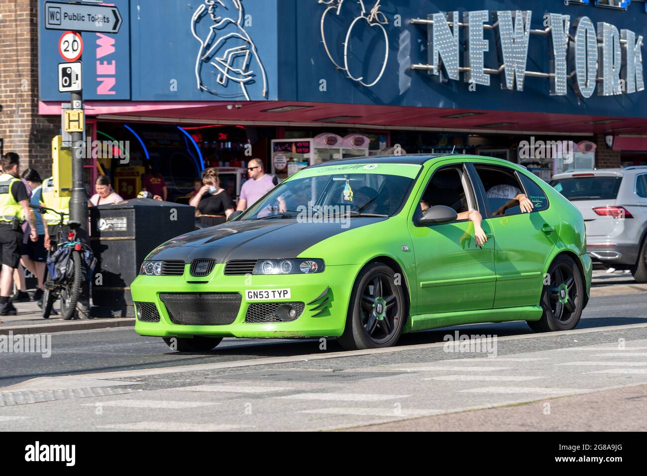 SEAT Leon custom car driving past cafes and amusement arcades on Marine Parade, Southend on Sea, Essex, UK. Lowered, modified. Youngsters inside Stock Photo