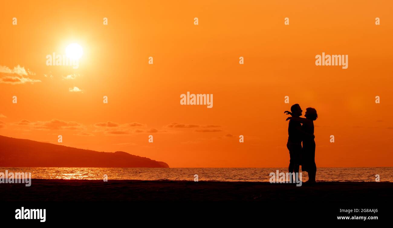 Couple embracing at beach, silhouette in sunset, love and friendship ...