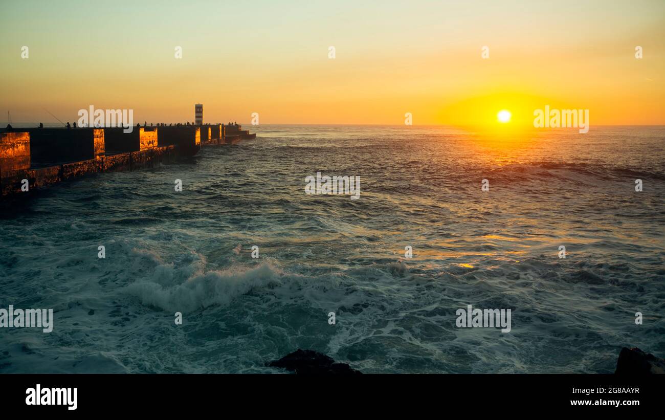 View of the ocean pier with the surf during a stunning sunset. Stock Photo