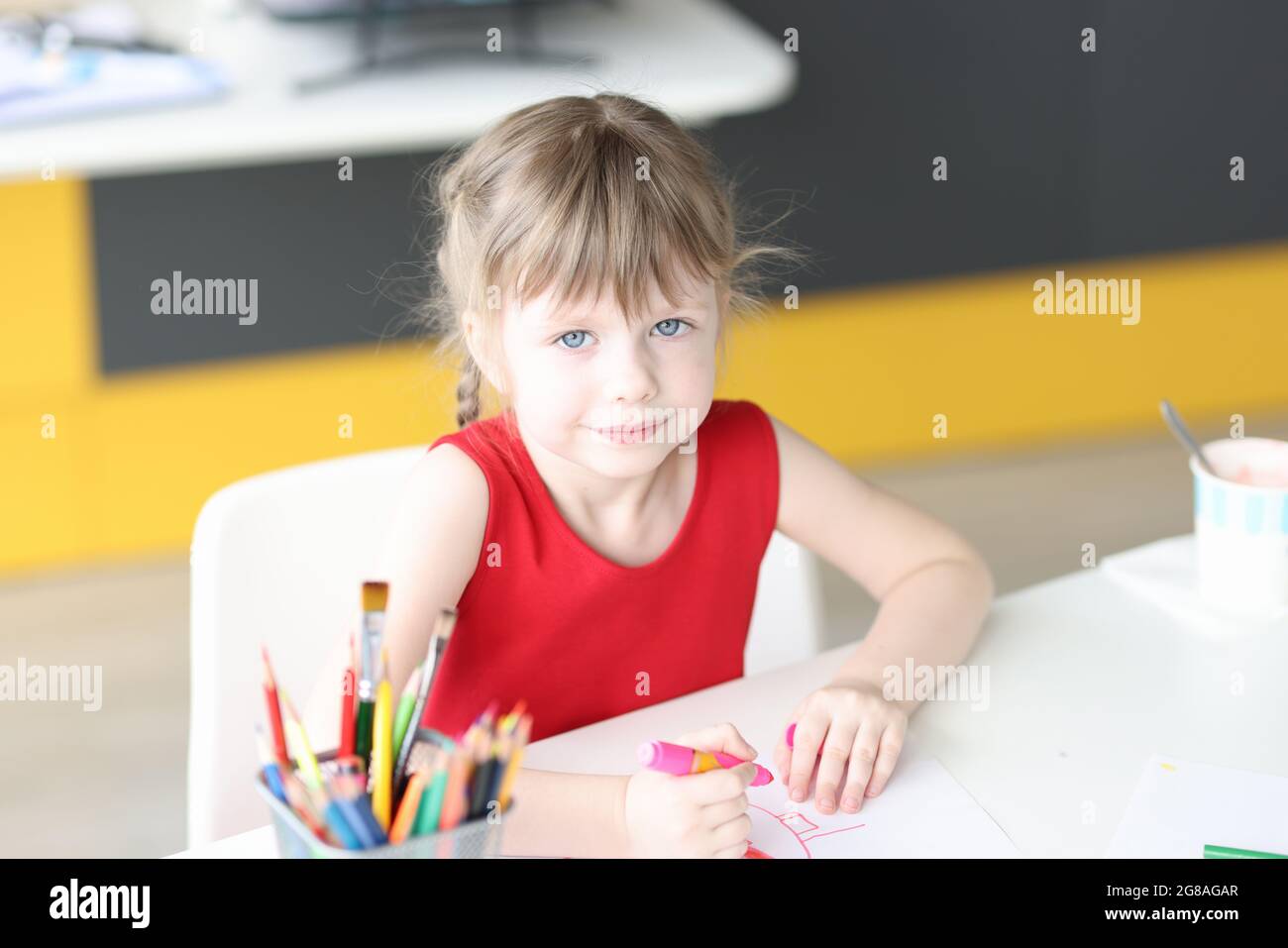 Little girl draws with colored pencils on paper closeup Stock Photo - Alamy