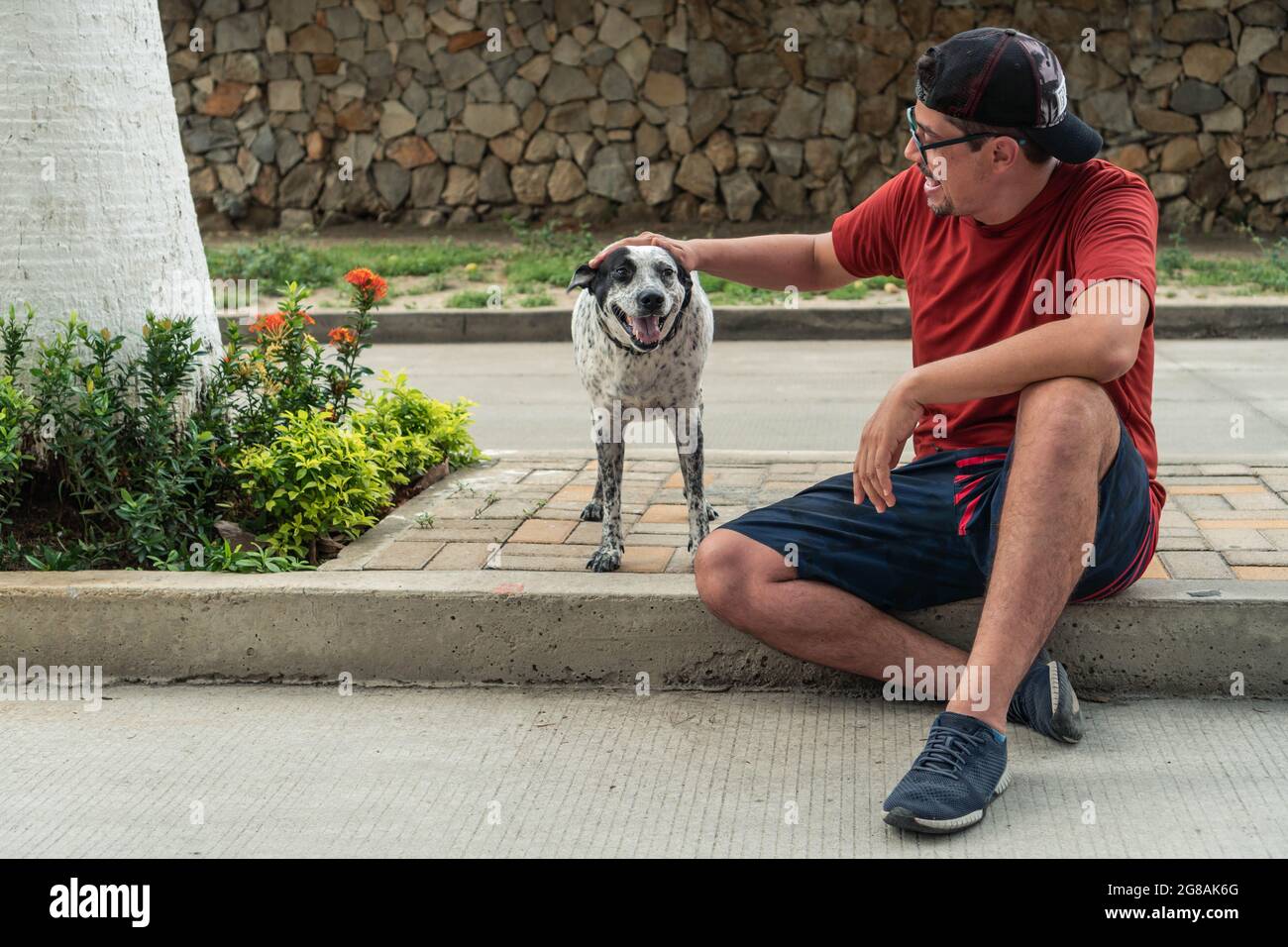 Older Man sitting outdoors with black and white dog Stock Photo - Alamy