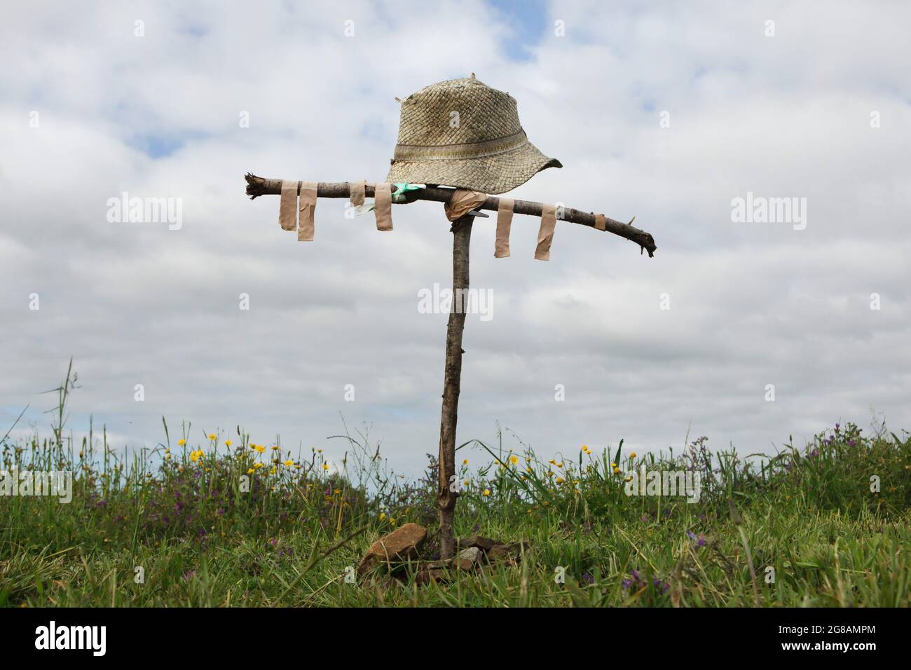 Camino de Santiago (Way of Saint James). Wooden cross decorated with an old straw hat and used adhesive bandages erected by unknown pilgrims on Monte do Gozo near Santiago de Compostela in Galicia, Spain. Monte do Gozo is the last stop on the French route and the Northern route of the Camino de Santiago from where pilgrims see the destination city for the first time. Stock Photo