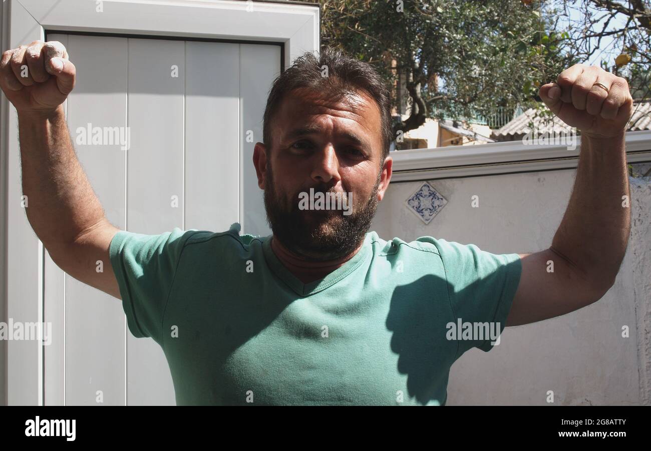 Man with beard raising arms Stock Photo