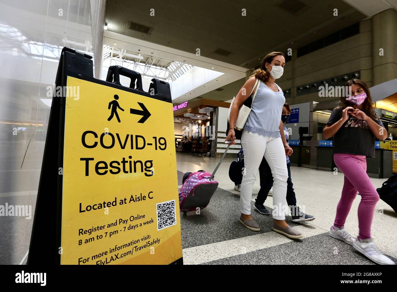 Los Angeles, USA. 19th July, 2021. Travelers with face masks are seen at the Los Angeles International Airport in Los Angeles, the United States, July 18, 2021. Public health authorities in Los Angeles County announced on Thursday that the most populous county in the United States will require all residents to wear masks in indoor public spaces, regardless of vaccination status, due to increased COVID-19 transmission. Credit: Xinhua/Alamy Live News Stock Photo