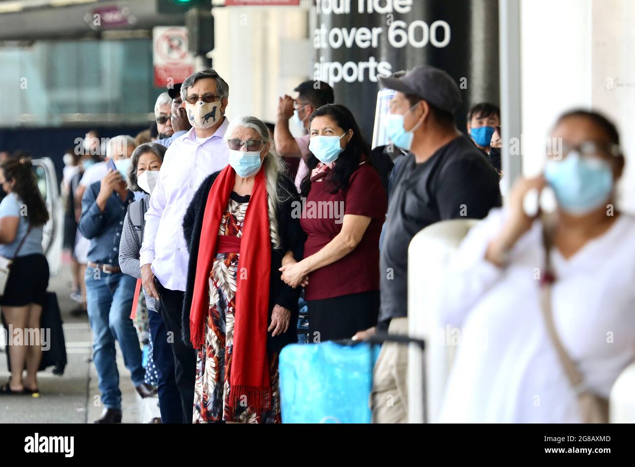 Los Angeles, USA. 19th July, 2021. Travelers with face masks are seen at the Los Angeles International Airport in Los Angeles, the United States, July 18, 2021. Public health authorities in Los Angeles County announced on Thursday that the most populous county in the United States will require all residents to wear masks in indoor public spaces, regardless of vaccination status, due to increased COVID-19 transmission. Credit: Xinhua/Alamy Live News Stock Photo