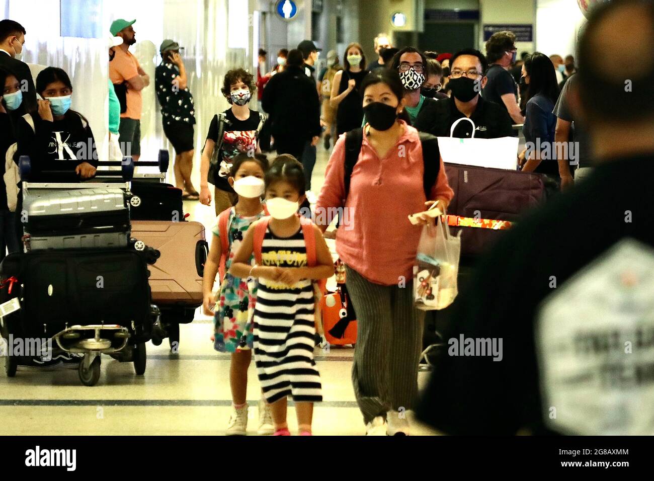 Los Angeles, USA. 19th July, 2021. Travelers with face masks are seen at the Los Angeles International Airport in Los Angeles, the United States, July 18, 2021. Public health authorities in Los Angeles County announced on Thursday that the most populous county in the United States will require all residents to wear masks in indoor public spaces, regardless of vaccination status, due to increased COVID-19 transmission. Credit: Xinhua/Alamy Live News Stock Photo