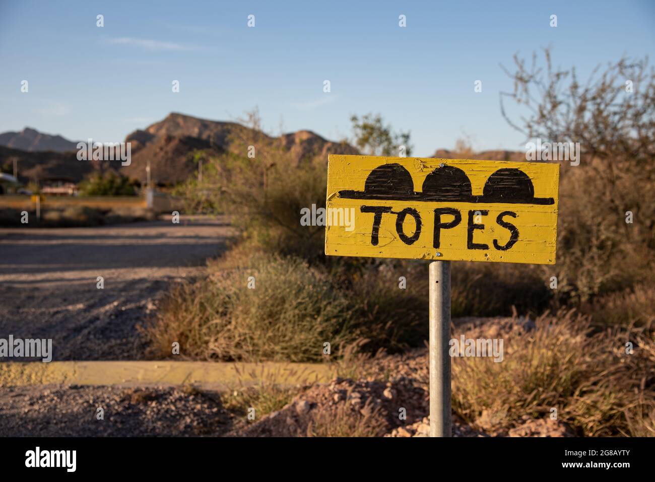 .A yellow sign cautions drivers of upcoming speed bumps, the words written in Spanish “words.” Stock Photo