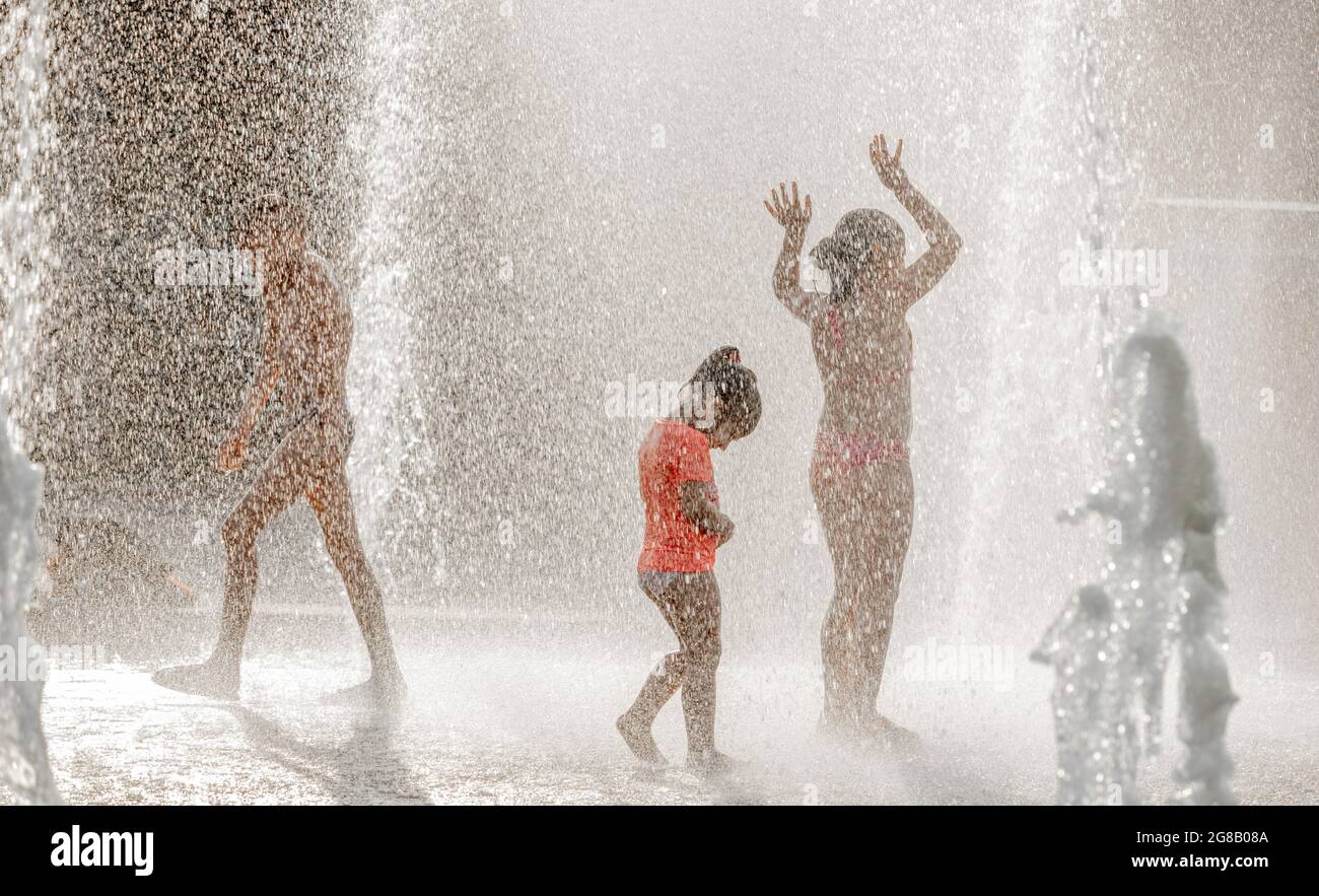 Silhouettes of children playing in a water fountain, in Summer, Park of Saint-Petersburg 300 ann., Russia Stock Photo