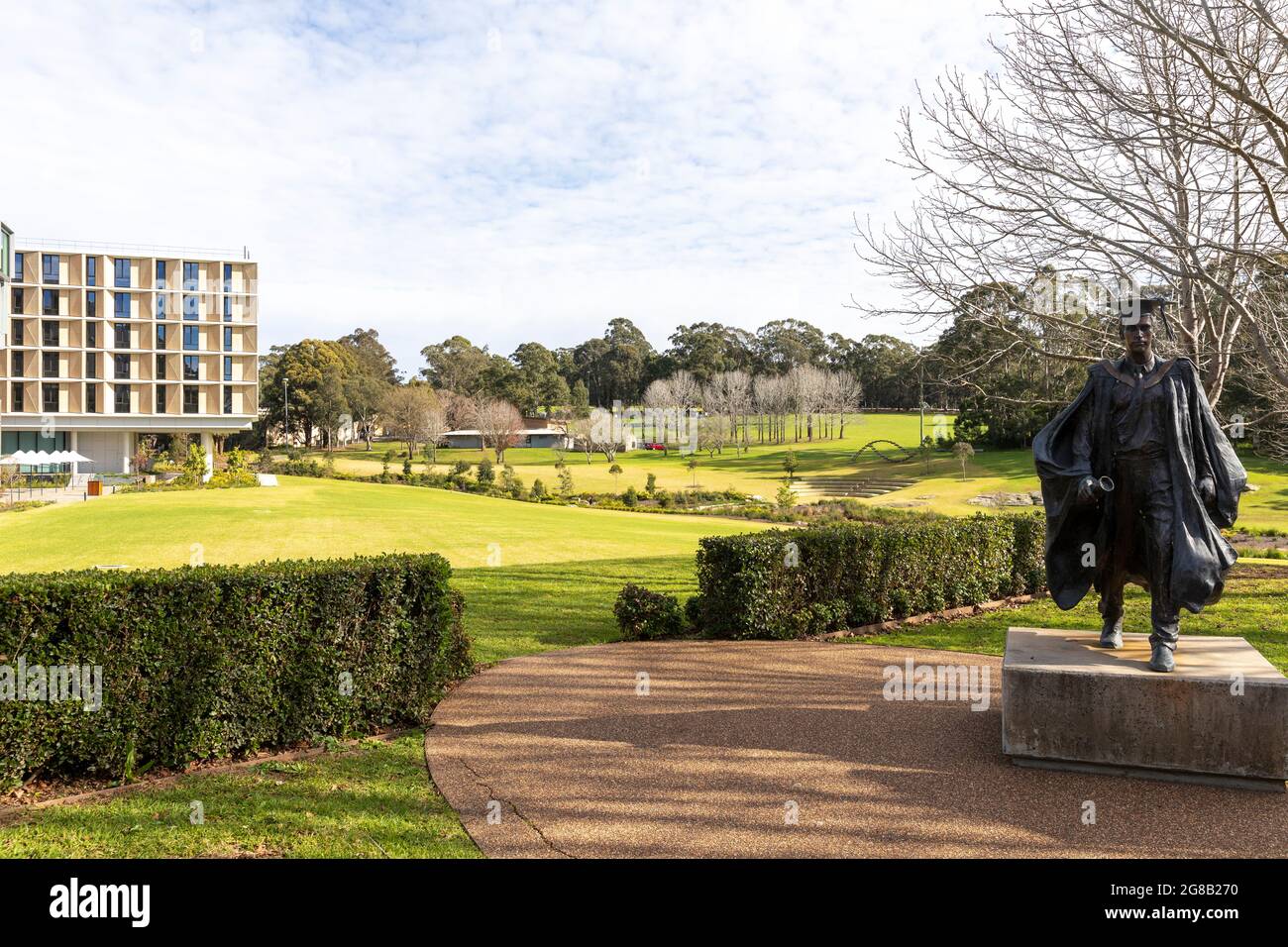 Macquarie University education campus in Macquarie Park with statue of a student wearing cape and mortar board hat,Sydney,Australia Stock Photo