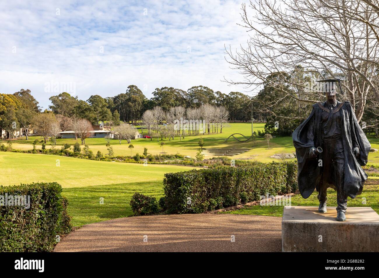 Macquarie University education campus in Macquarie Park with statue of a student wearing cape and mortar board hat,Sydney,Australia Stock Photo