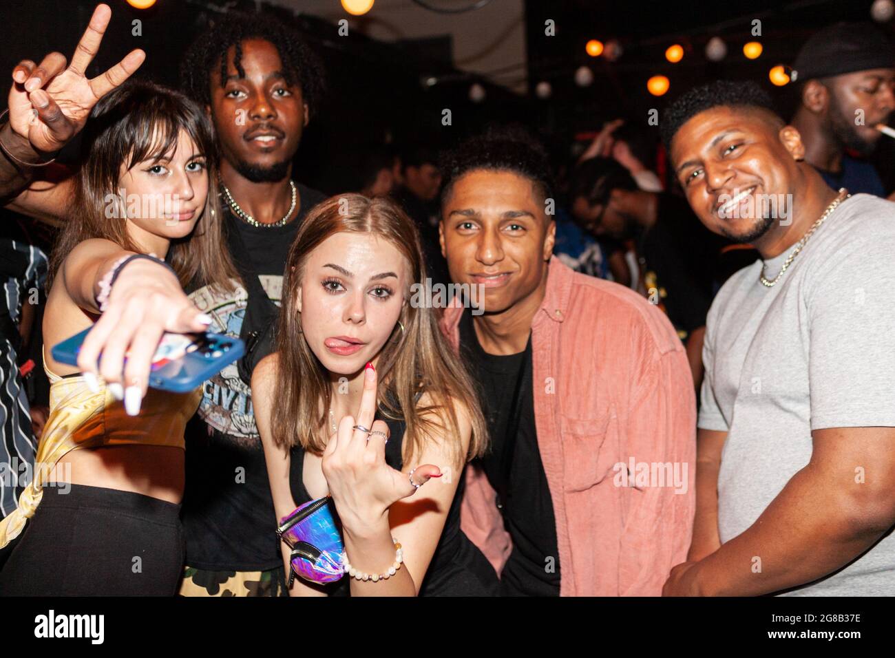 London, England. 18 Jul 2021. Clubgoers on opening night in the smoking area of Orange Yard, finally conversing without masks, and partying in public spaces. Credit: Stefan Weil/Alamy Live News Stock Photo
