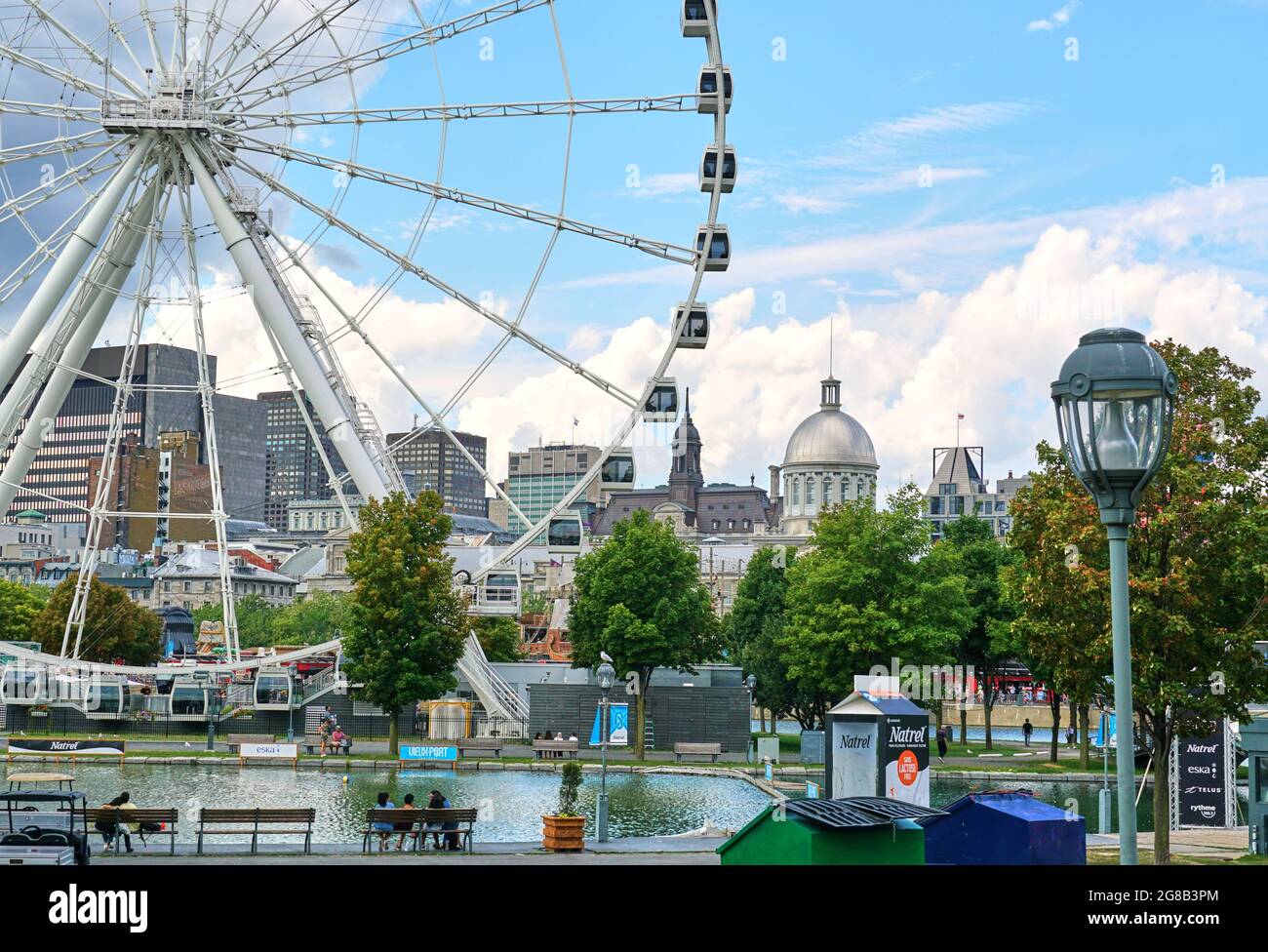 Canada, Montreal - July 11, 2021: Scenic view of Old Port of Montreal. Ferris wheel La Grande Roue, Bonsecours Market, City Hall buildings over blue s Stock Photo