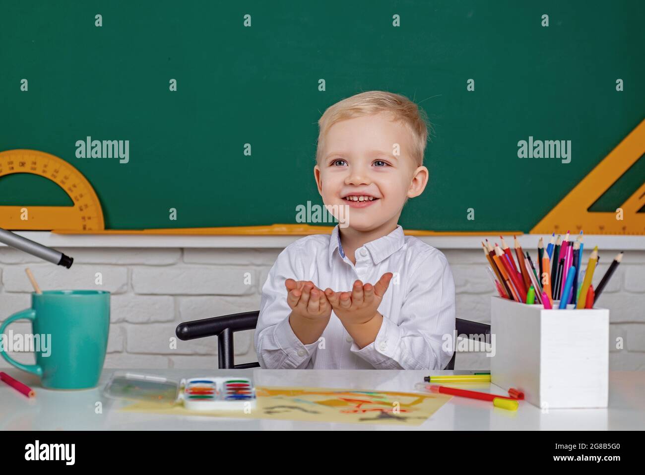 Kids gets ready for school. Friendly child in classroom near blackboard desk. Individual teaching Stock Photo Alamy