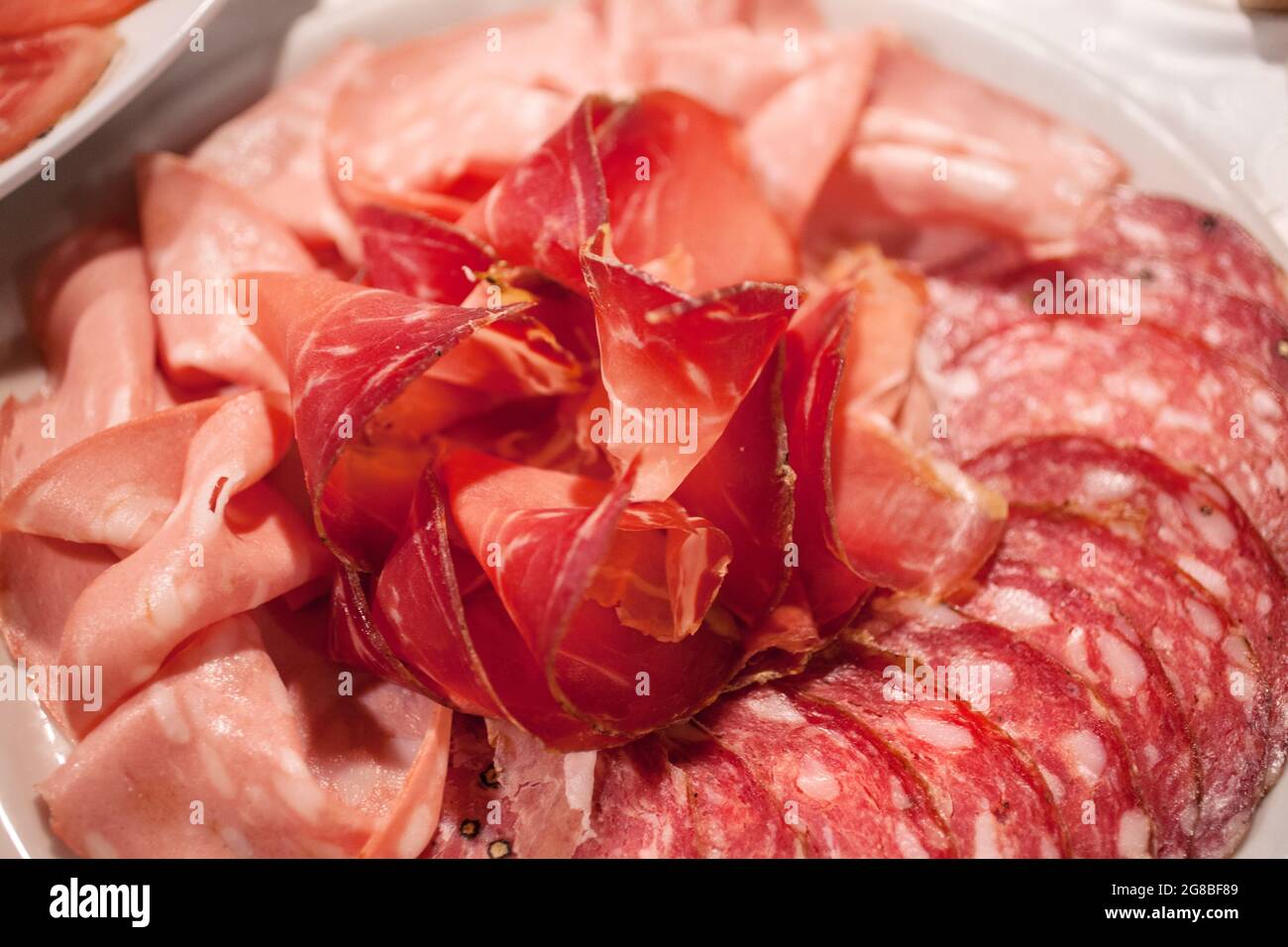 Plate with italian salami, ham and mordadella served on a buffet table
