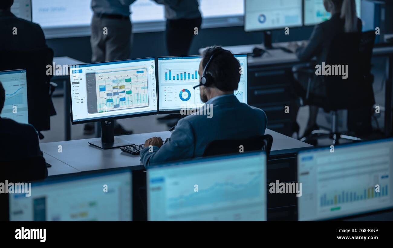 Professional Male Trade Specialist is Working on a Computer with Big