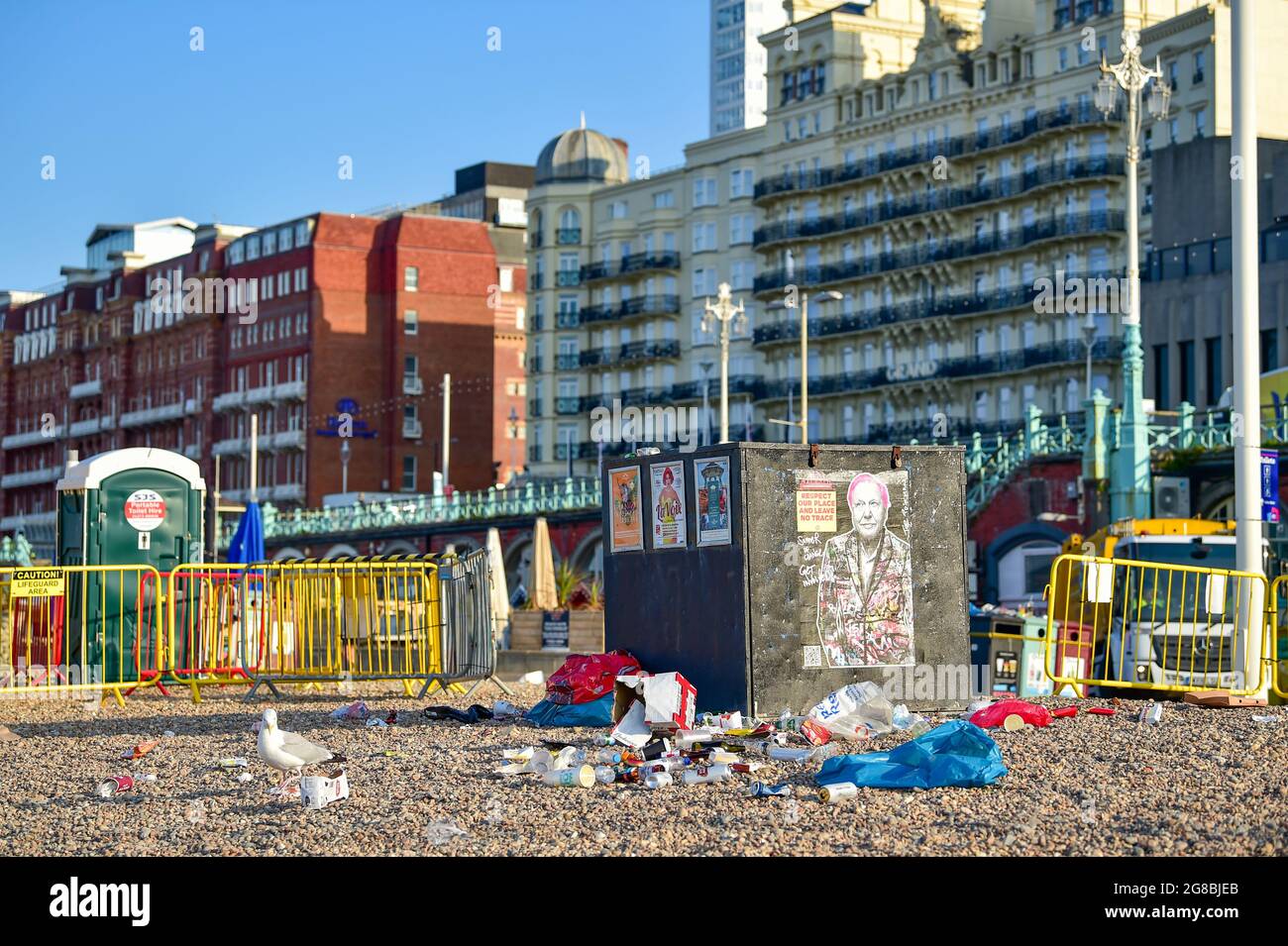 Brighton UK 19th July 2021 - Rubbish left behind on Brighton beach after crowds flocked to the seaside in the hot weather over the weekend . Council staff were out from 5am in the morning cleaning up the beach and seafront : Credit Simon Dack / Alamy Live News Stock Photo