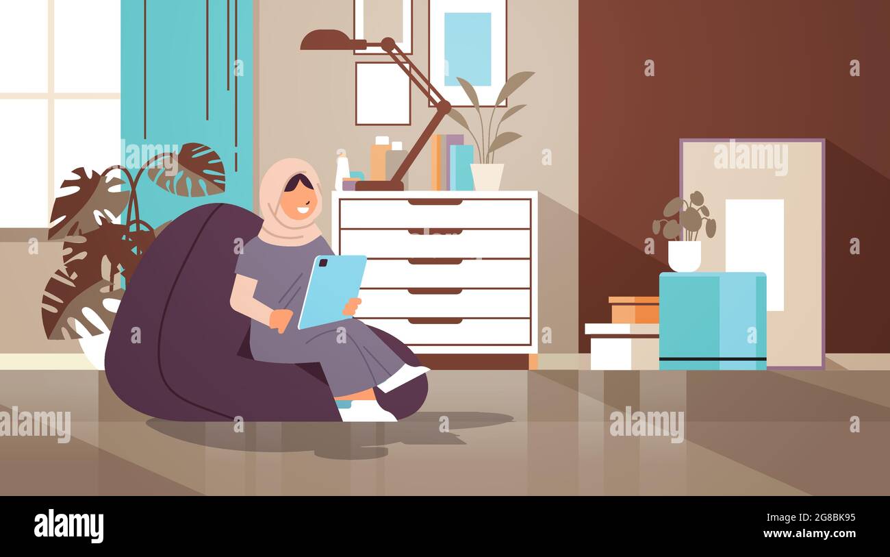 arab schoolgirl using tablet pc arabic girl sitting on beanbag and ...