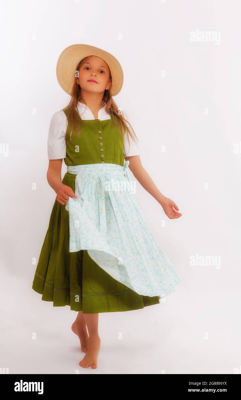 Dancing girl in dirndl with hat holding your apron in one hand and spinning. Stock Photo